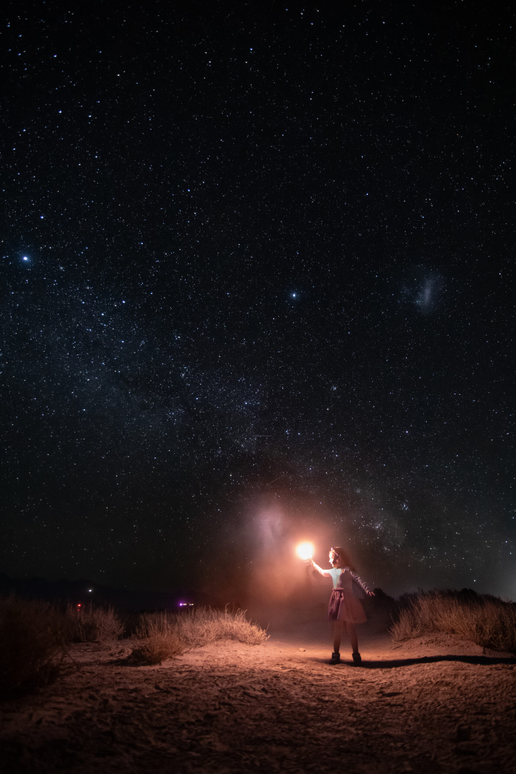 Foto de niña pequeña sosteniendo luz hacia las estrellas